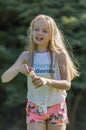 Portrait of a teenage girl long blond hair, having fun in the garden blowing bubbles Royalty Free Stock Photo