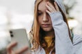 Portrait of teenage girl looking at her smartphone, sad, anxious, alone. Cyberbullying, girl is harassed, threated Royalty Free Stock Photo