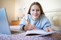 Portrait Of Teenage Girl Lying On Bed In Bedroom With Laptop Studying And Home Schooling Royalty Free Stock Photo