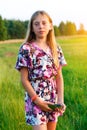 Portrait of teenage girl poses and holding smart phone. Front view of Charming teen girl in summer standing on the Royalty Free Stock Photo