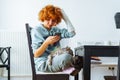 Portrait teenage girl with red hair, cast on arm and domestic cat at home Royalty Free Stock Photo