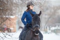 Portrait of teenage girl riding raven horse in winter Royalty Free Stock Photo