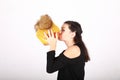 Teenage girl kissing pumpkin in yellow cap with bobbles Royalty Free Stock Photo