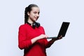 Teenage girl student in headphones using laptop on white background Royalty Free Stock Photo