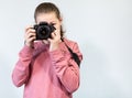 Portrait of teenage girl taking picture with DSLR camera, front view during shooting, grey background, copyspace Royalty Free Stock Photo