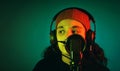 Portrait of a teenage girl wearing a hat made of wool, singing with headphones and a microphone, studio shot, close up look, with Royalty Free Stock Photo