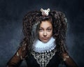 Portrait of a teenage girl with a white mouse on her dark curly hair