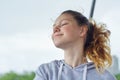 Portrait of teenage girl 15 years old, dreaming girl with closed eyes, smiling pretty female in gray sweatshirt Royalty Free Stock Photo