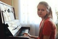 Portrait of a teenage girl 14-years old playing the piano at home Royalty Free Stock Photo