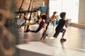 Portrait of teenage kids training using fitness straps in gym with female trainer. Sport, healthy lifestyle, physical