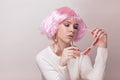 Portrait of teenage model with pink hair posing against pastel background