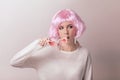 Portrait of teenage model with pink hair posing against pastel background