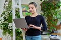 Portrait of teenage smiling girl using laptop, home room interior Royalty Free Stock Photo