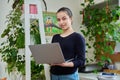 Portrait of teenage smiling girl using laptop, home room interior Royalty Free Stock Photo