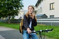 Portrait of teenage student girl with backpack on bicycle talking on phone Royalty Free Stock Photo