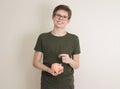 Portrait of teenager boy holding piggy bank and coin. Cute caucasian young teenager on white background. Saving Money concept. Royalty Free Stock Photo