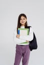 Portrait of teenager girl with school backpack holding colored folders on white background Royalty Free Stock Photo