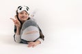 Portrait of a teenager girl with a soft toy shark in her hands in a kigurumi on a white background. Studio photo. Girl shows