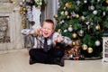 Portrait of teenager kid posing near Christmas tree in a nice room. Photoshoot in studio Royalty Free Stock Photo
