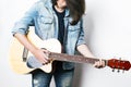 Fashion portrait of a teenager playing guitar in studio wearing jeans jacket Royalty Free Stock Photo