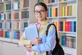 Portrait of teenager student girl looking at camera in library Royalty Free Stock Photo