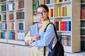 Portrait of teenager student girl looking at camera in library Royalty Free Stock Photo