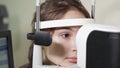 Portrait of teenager who undergoes the procedure of an ophthalmoscopy in clinic