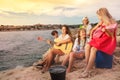 Happy friends having picnic outdoors on the beach Royalty Free Stock Photo