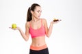 Portrait of tempted attractive fitness woman making food choice Royalty Free Stock Photo