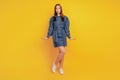 Portrait of tempting adorable lady send air kiss wear denim mini dress on yellow background