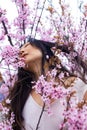 portrait of tender asian woman at sakura flowers background. Hanami celebration in sakura blooming garden.