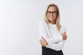 Portrait of tender and elegant blond woman in glasses and office outfit hugging herself to warm-up on winter morning as