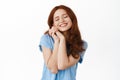 Portrait of tender happy girl with red curly hair, imaging something romantic, close eyes and smile cheerful