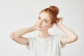 Portrait of tender redhead girl with hair bun and freckles smiling. Royalty Free Stock Photo