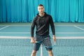 Portrait of a tennis player. athlete holds racket on court