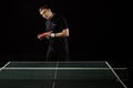 portrait of tennis player in uniform with racket standing at tennis table Royalty Free Stock Photo