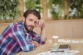 Portrait of tensed executive with laptop siting at desk