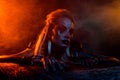 Portrait of terrifying valkyrie war woman scary red lights misty fog isolated on dark colorful background