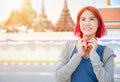 Portrait Thai Asian girl new generation young pop teen dyed red hair color shade smiling with Thailand temple background