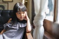 Portrait Thai Asian kid girl, aged 4 to 6 years old, long hair, wearing fashionable clothes, beautiful and cute face.She sits in Royalty Free Stock Photo