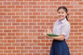 portrait Thai Asian school student in uniform standing smile with pencil and pocket memo book
