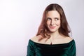 Portrait of thinkful woman with freckles and classic green dress. studio shot on silver gray background