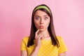 Portrait of thinking pretty brunette girl finger chin blow kiss wear yellow cloth isolated on pastel pink color