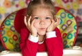 Portrait of thinking and sad little girl propping head by hands