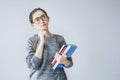 Portrait of thinking student girl on grey background Royalty Free Stock Photo