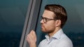 Portrait of a thinking young man in the evening office Royalty Free Stock Photo