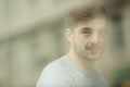 Portrait of thinking young man near glass window. Looking in the window. Reflection from model on the glass. Royalty Free Stock Photo