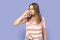 Thirsty attractive beautiful young adult blond woman drinking water from glass, healthy eating. Royalty Free Stock Photo