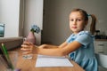 Portrait of thirsty elementary little girl writing in exercise book, taking break and drinking fresh cool filtered clear Royalty Free Stock Photo