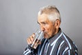 Portrait of a thirsty senior man drinking water